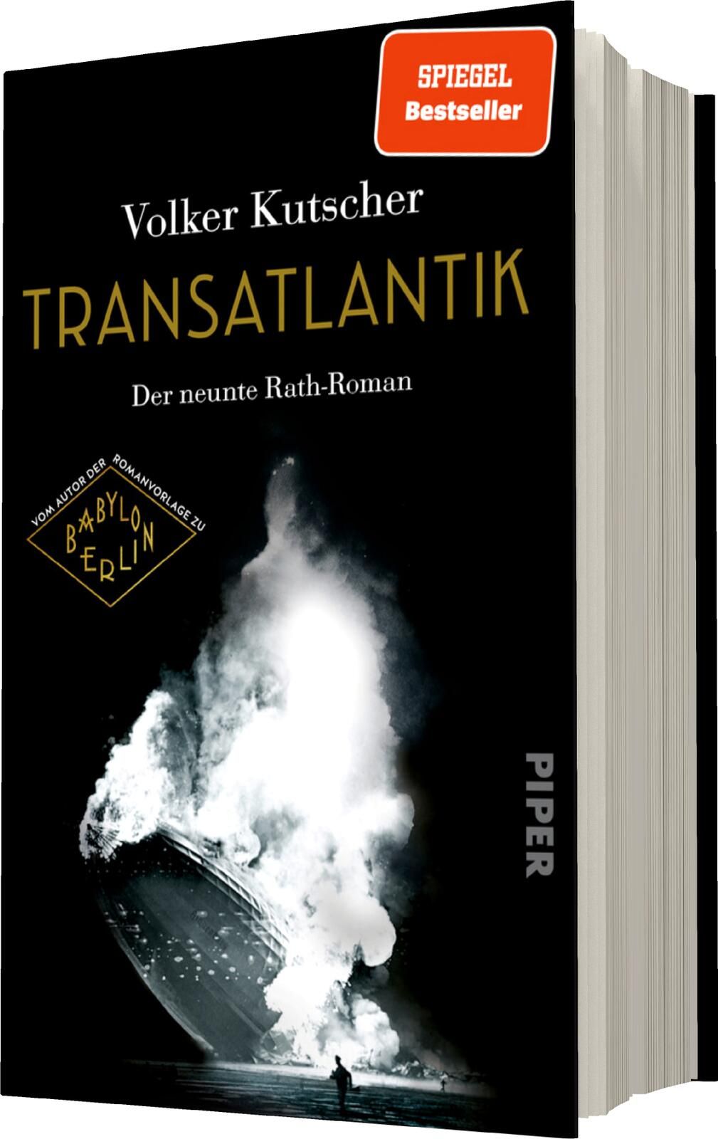 Das Buchcover zeigt einen dramatischen schwarz-weißen Hintergrund, der eine stürmische See mit einer Wasserfontäne darstellt. Oben steht in goldener Schrift „TRANSATLANTIK“ und darunter in kleinerem Weiß „Der neunte Rath-Roman“. Der Autorenname „Volker Ku