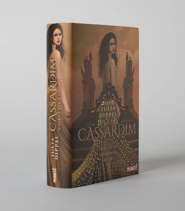 Das Buchcover zeigt eine junge Frau mit langen, lockigen Haaren, die in einem goldenen Kleid mit leuchtenden Akzenten gekleidet ist, vor einer stilvollen Kulisse. Die Farben sind warm und nostalgisch, mit einem dominierenden Goldton und sanften braunen Nu