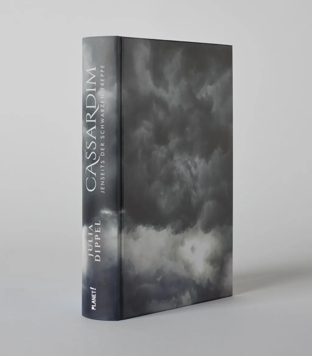 Das Buchcover zeigt einen dramatischen Himmel in Grautönen mit kräftigen, dunklen Wolken. Der Titel „Cassardim“ steht gut lesbar in vertikaler Ausrichtung auf dem Cover.