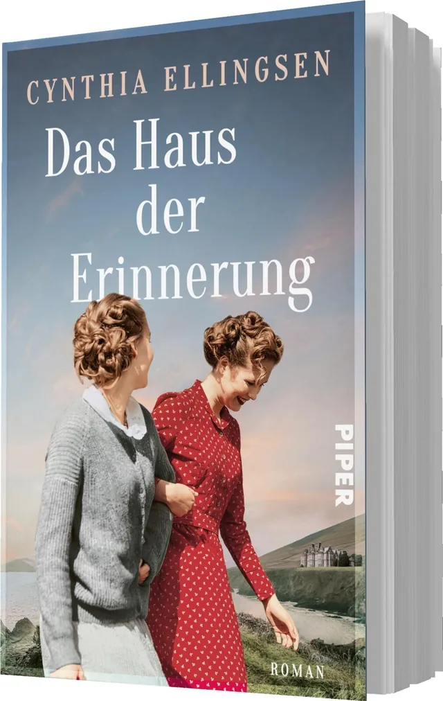 Das Buchcover zeigt zwei Frauen in zeitgenössischer Kleidung, die eng beieinander stehen und lächeln. Die Frau links trägt einen grauen Pullover, die rechte wählt ein rotes Kleid. Im Hintergrund erstreckt sich eine malerische Landschaft mit sanften Hügeln
