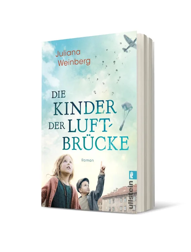 Cover von „Die Kinder der Luftbrücke“ von Juliana Weinberg: Zwei Kinder stehen in einer Stadtlandschaft, während im Hintergrund Flugzeuge am Himmel fliegen. Der Himmel ist hell und wolkig, und das Cover hat eine melancholische Stimmung.