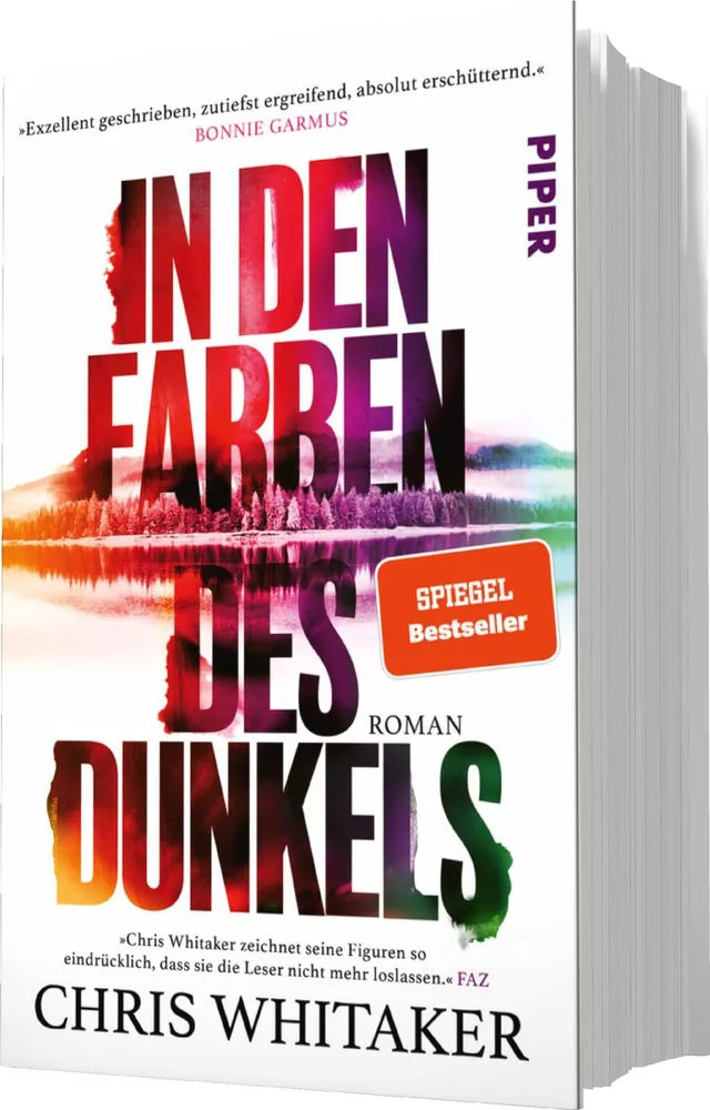 Das Buchcover zeigt einen künstlerisch gestalteten Hintergrund mit einem Wald, der sich in einem ruhigen Gewässer spiegelt. Die Farben variieren von kräftigem Lila bis zu sanften Rottönen und stellen eine düstere, geheimnisvolle Atmosphäre dar. Der Titel