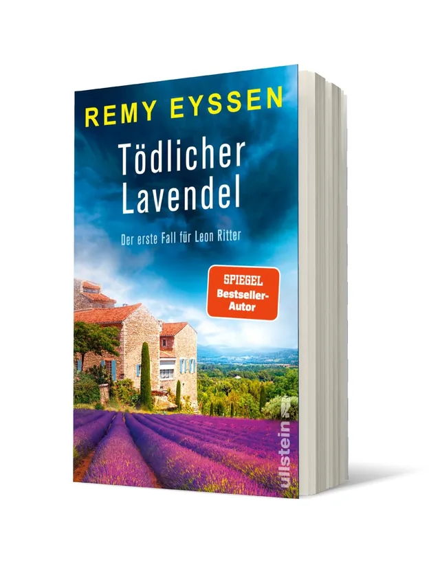 Cover von „Tödlicher Lavendel“ von Remy Eyssen: Eine malerische Landschaft mit lila Lavendelfeldern und einem ländlichen Haus unter einem bewölkten Himmel.